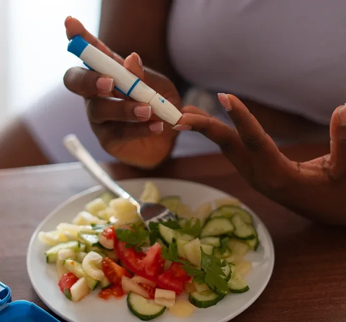 Woman checking her blood sugar before a healthy meal